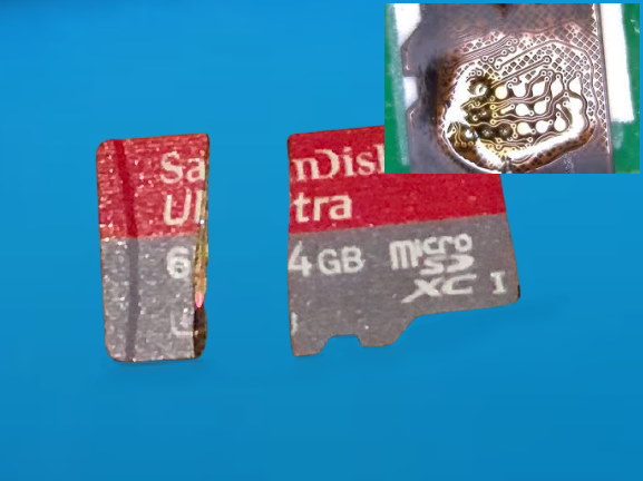 A physically broken microSD card showing internal damage.